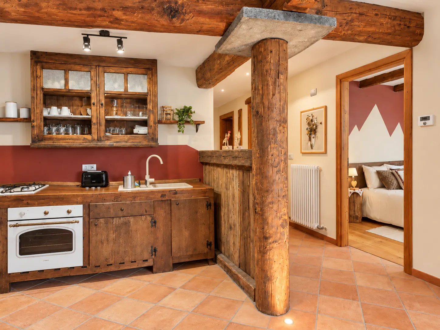 Cucina con trave in legno e colonna